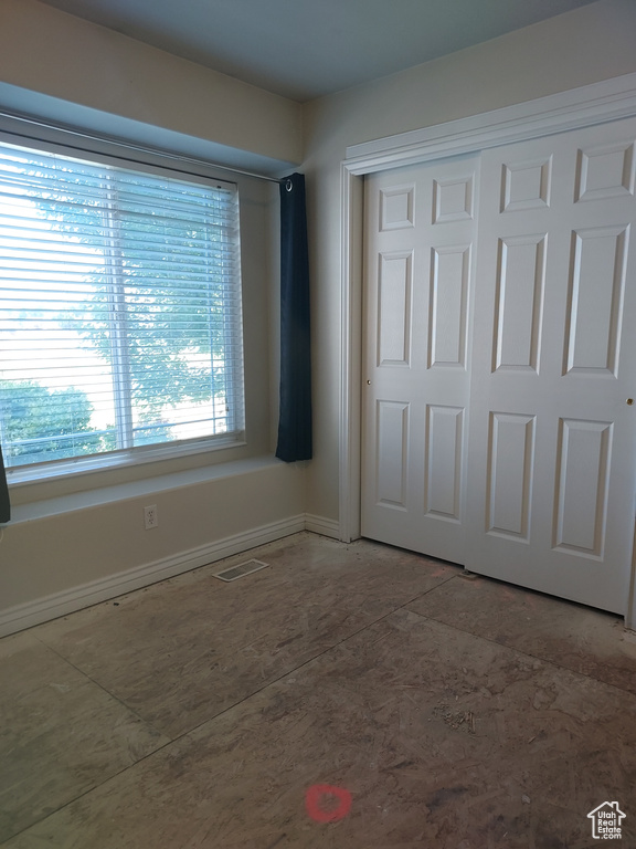 Unfurnished bedroom featuring a closet and baseboards