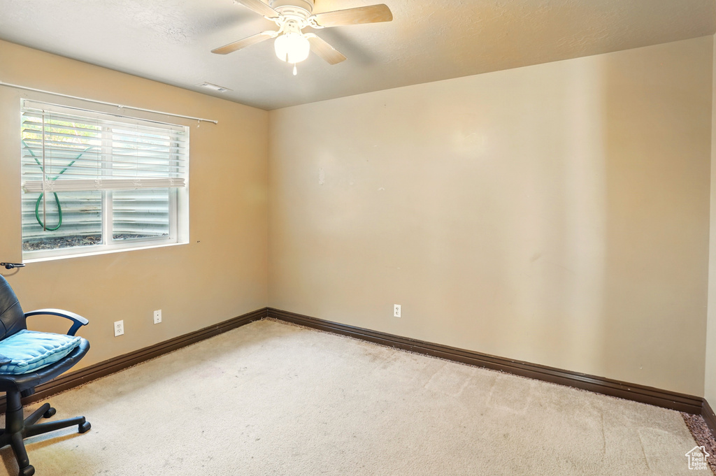 Unfurnished office with carpet floors, a ceiling fan, and baseboards