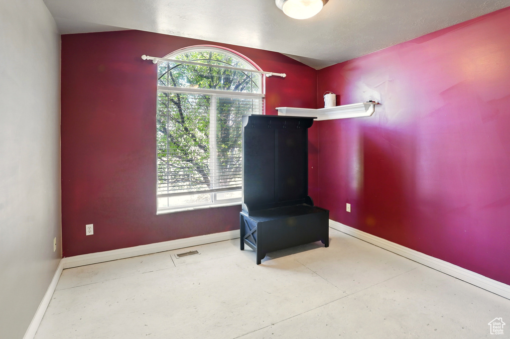 Unfurnished room with baseboards, plenty of natural light, and concrete floors