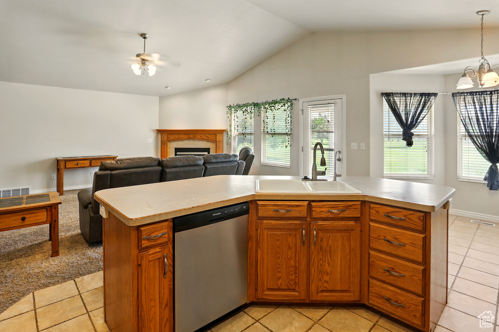 Kitchen featuring a sink, stainless steel dishwasher, light countertops, plenty of natural light, and lofted ceiling