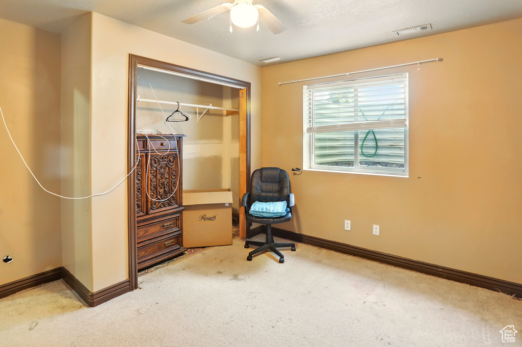Living area featuring carpet, a ceiling fan, baseboards, and a desk