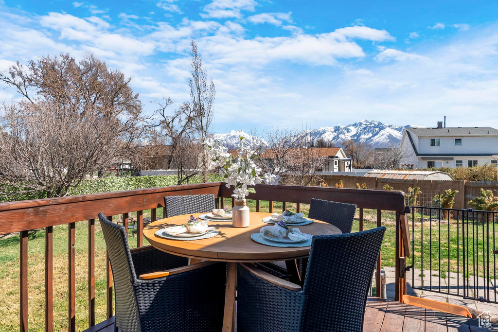 Wooden deck with outdoor dining space and a mountain view