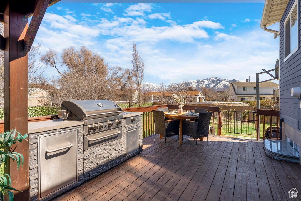 Wooden deck with a mountain view and outdoor dining area