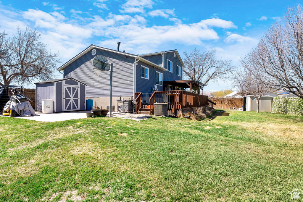 Rear view of house featuring a deck, central air condition unit, and a patio