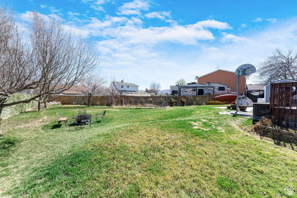 View of yard with an outdoor fire pit and a hot tub
