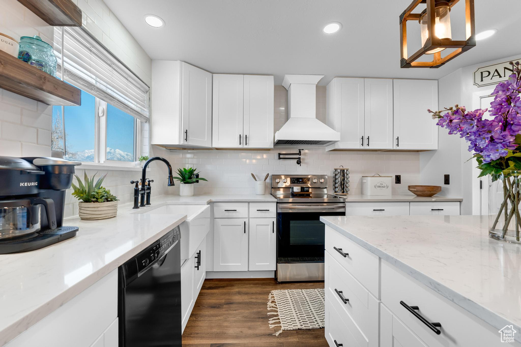 Kitchen with stainless steel electric range oven, black dishwasher, custom exhaust hood, a sink, and decorative backsplash