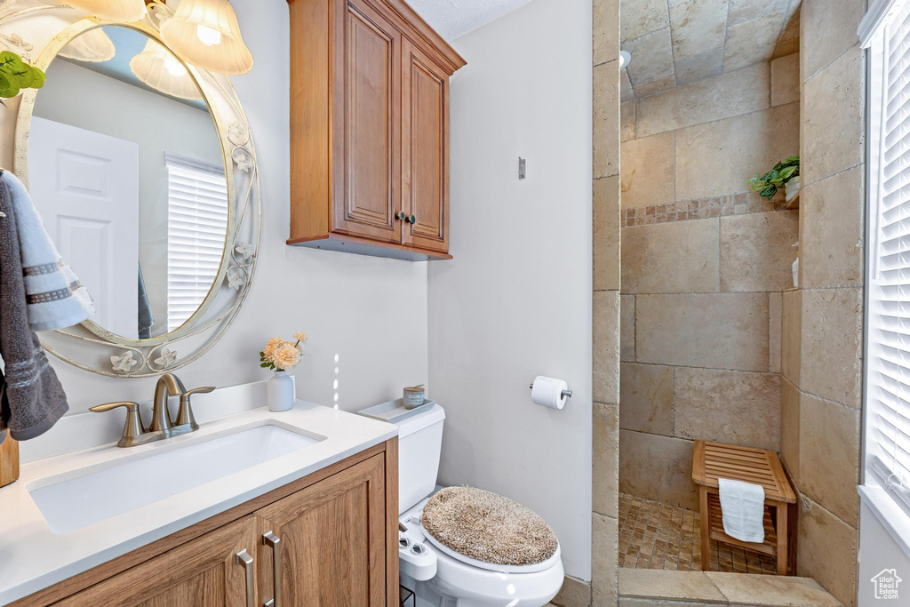 Full bath with toilet, vanity, and a walk in shower