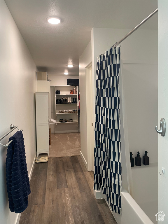 Hallway featuring dark wood-style flooring and baseboards