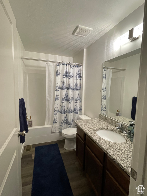 Full bath with vanity, toilet, shower / bathtub combination with curtain, and wood finished floors