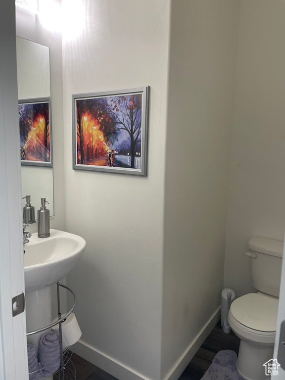 Half bathroom with toilet and baseboards