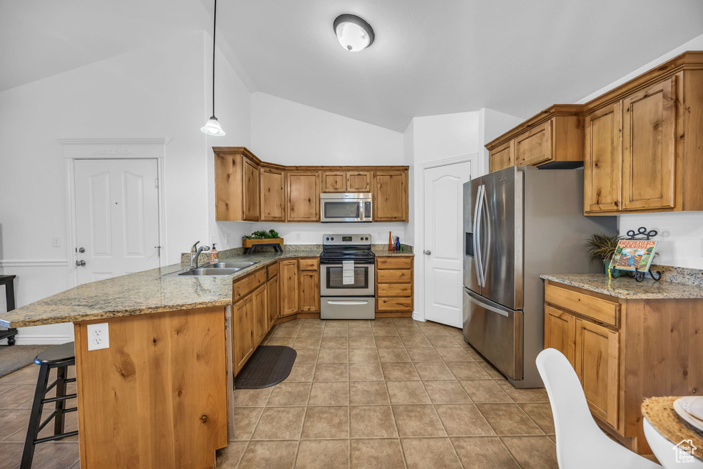 Kitchen featuring stainless steel appliances, a sink, a peninsula, a kitchen breakfast bar, and light tile patterned floors