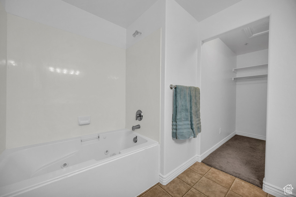 Bathroom with tile patterned flooring, baseboards, and a combined bath / shower with jetted tub