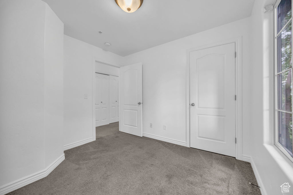 Unfurnished bedroom featuring carpet floors and baseboards