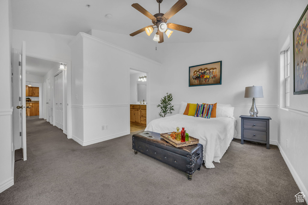 Bedroom featuring carpet floors, baseboards, connected bathroom, vaulted ceiling, and ceiling fan
