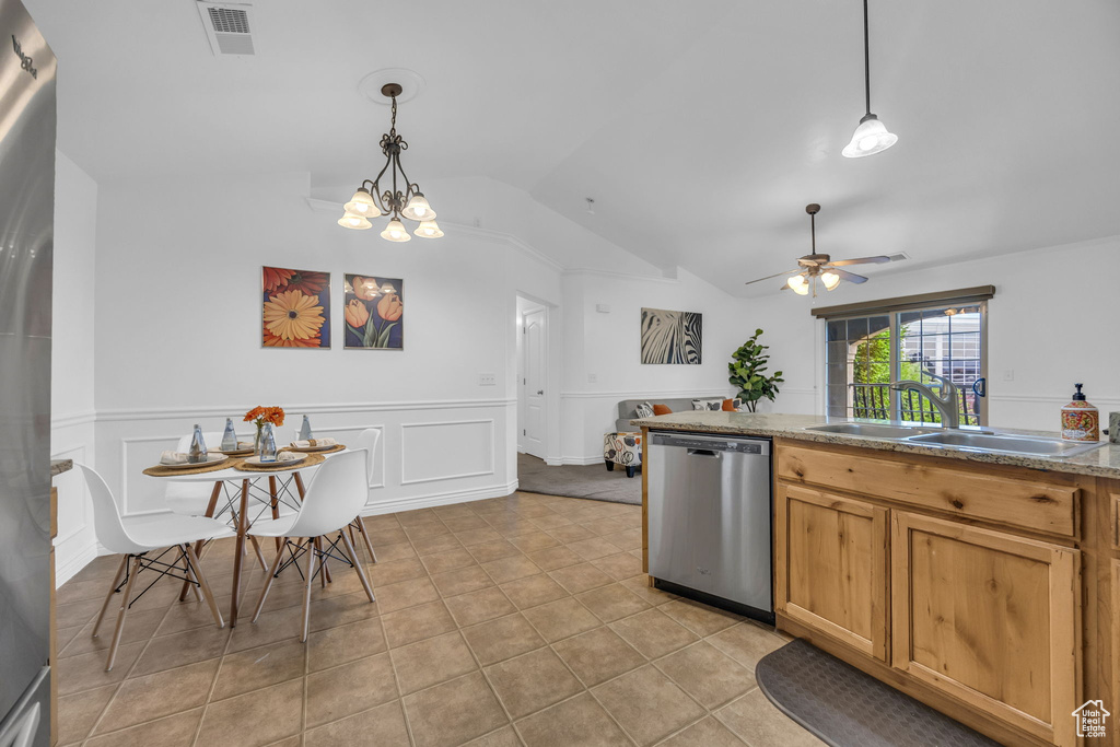 Kitchen with dishwasher, a sink, vaulted ceiling, a ceiling fan, and wainscoting