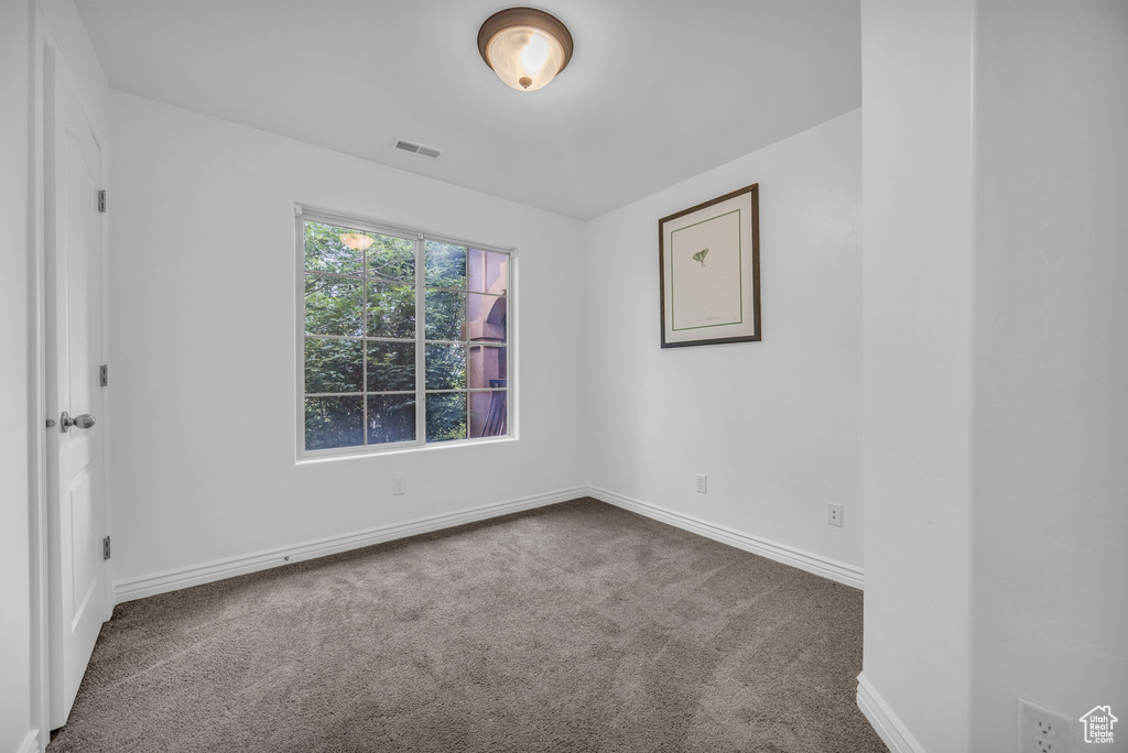 Empty room with carpet and baseboards