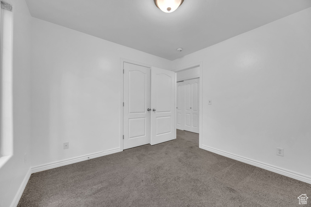 Unfurnished bedroom featuring carpet flooring and baseboards