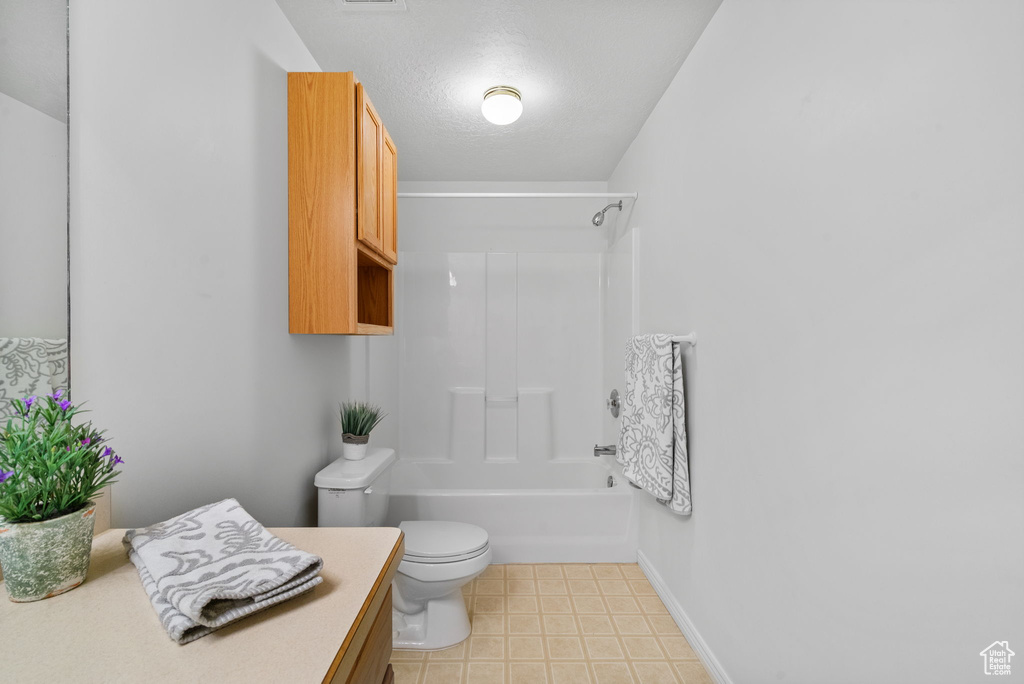 Full bathroom featuring vanity, toilet, shower / bath combination, and baseboards