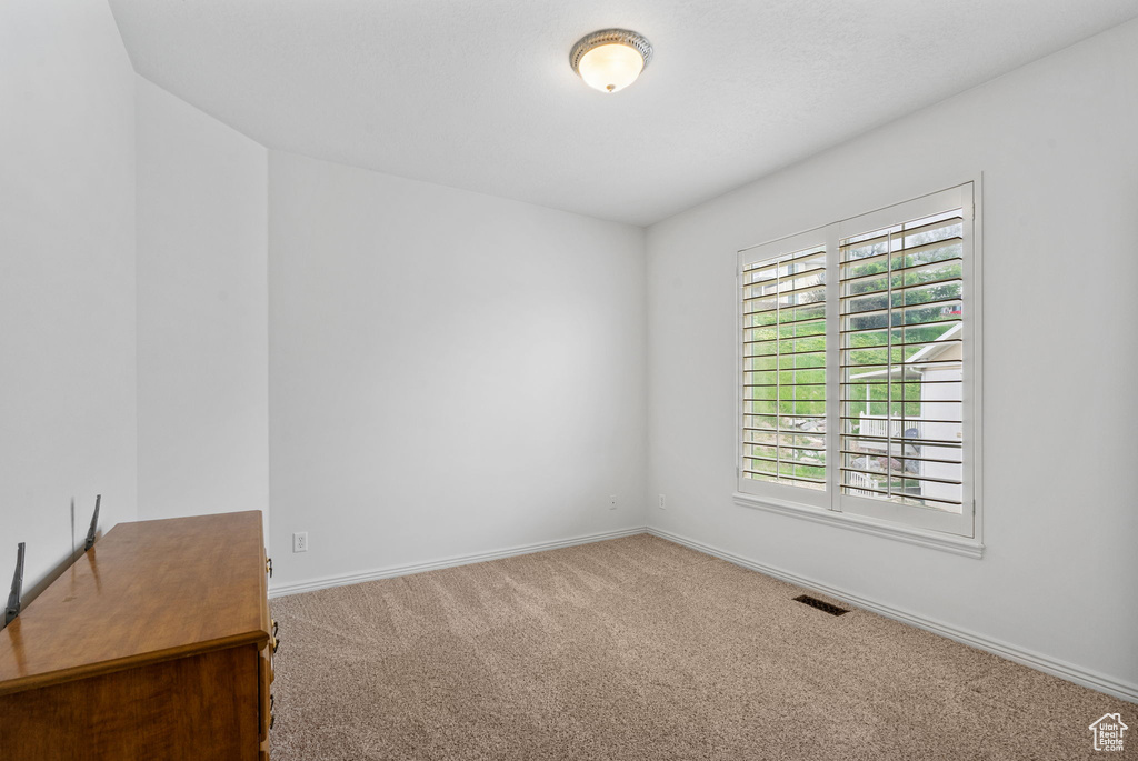 Unfurnished room featuring carpet and baseboards