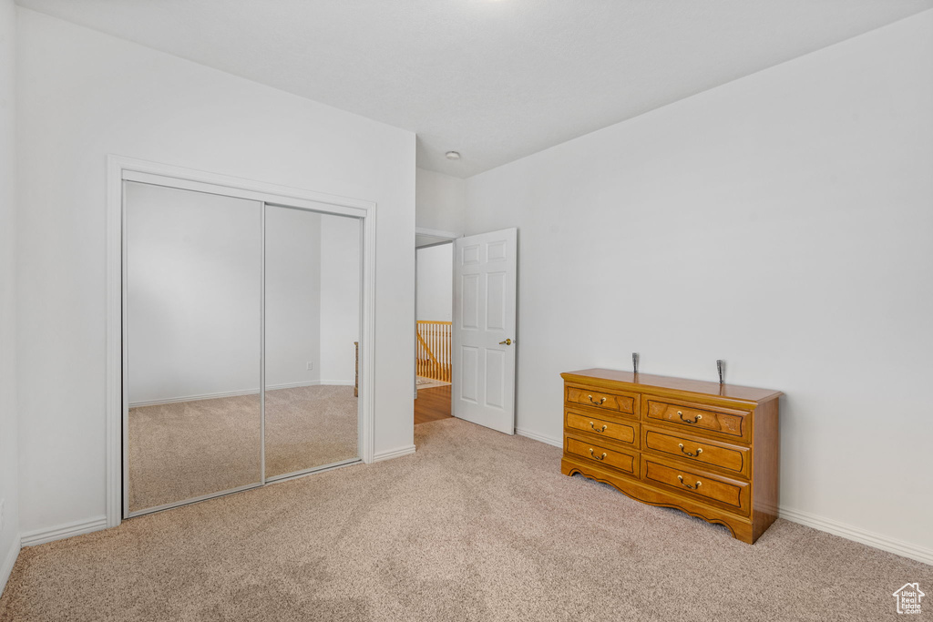 Carpeted bedroom featuring a closet and baseboards