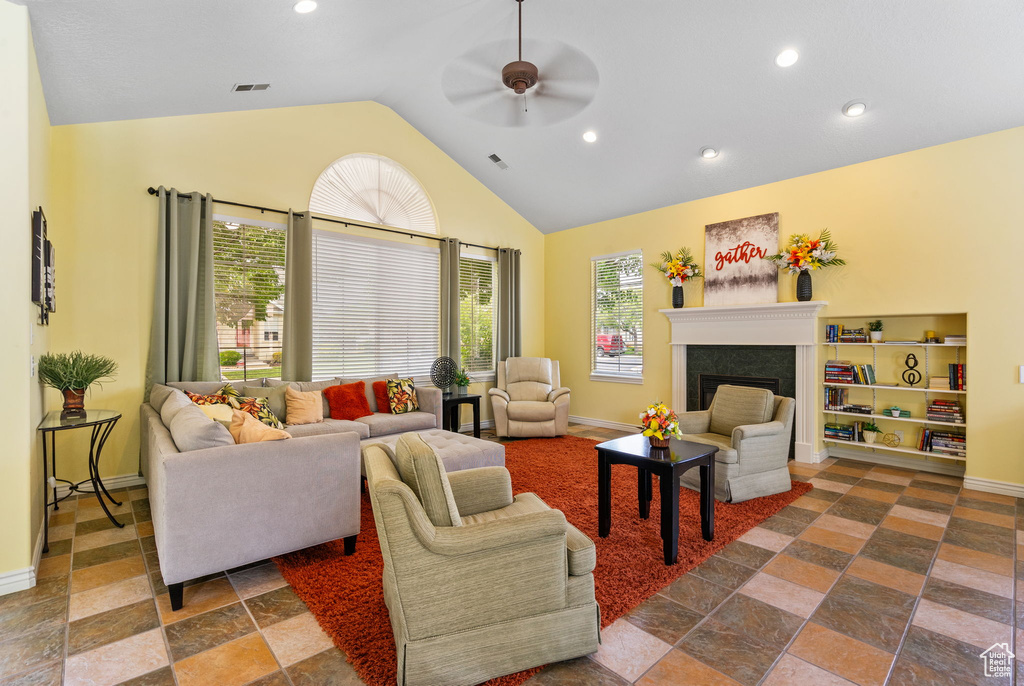 Living area with ceiling fan, recessed lighting, a fireplace, stone tile flooring, and baseboards