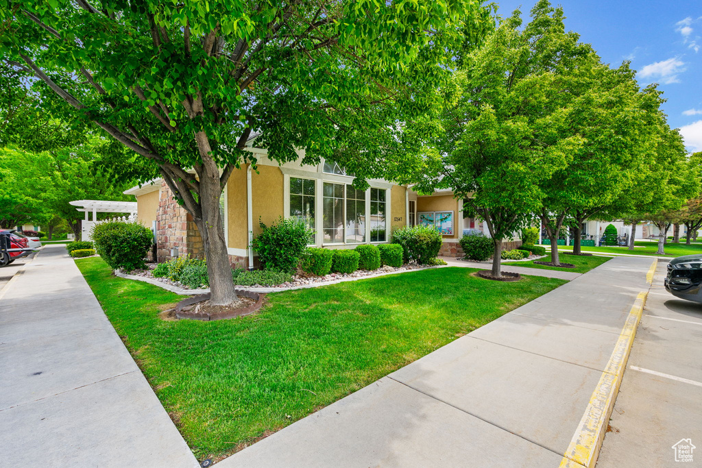 View of front of property featuring stucco siding and a front yard