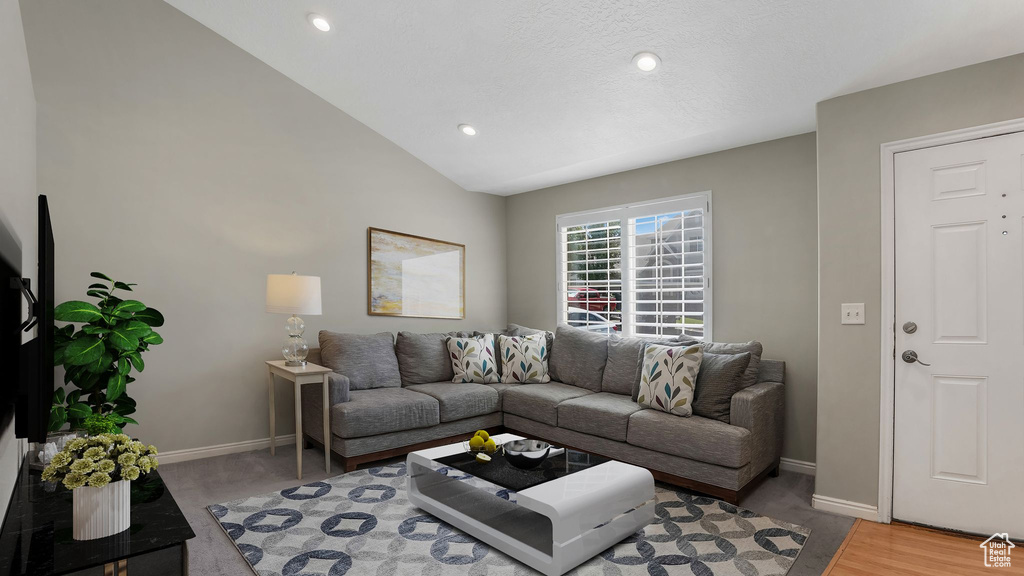 Living room with baseboards, lofted ceiling, and recessed lighting