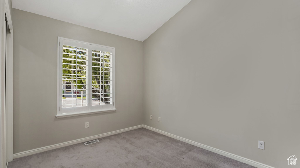 Empty room featuring baseboards and light carpet