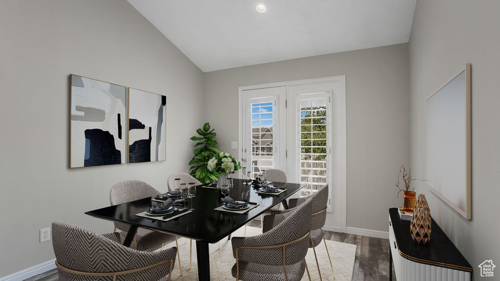 Dining area with wood finished floors, baseboards, and lofted ceiling