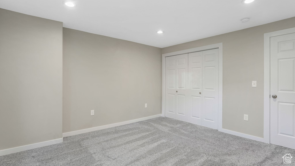 Unfurnished bedroom featuring carpet floors, recessed lighting, baseboards, and a closet