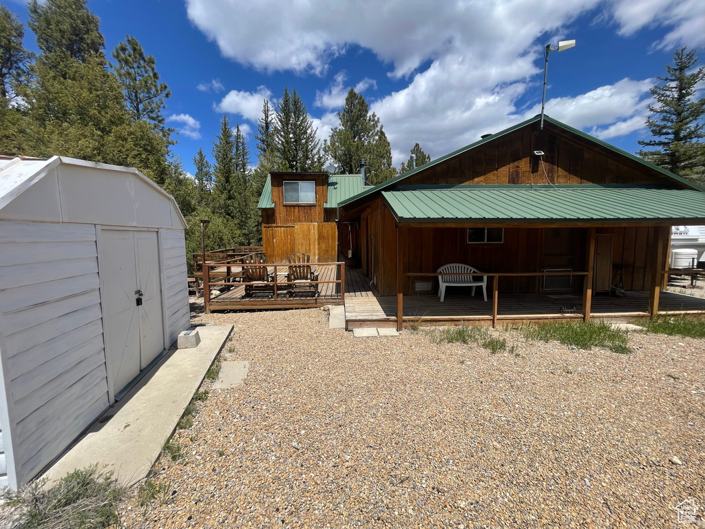 Back of house featuring metal roof, a deck, and board and batten siding