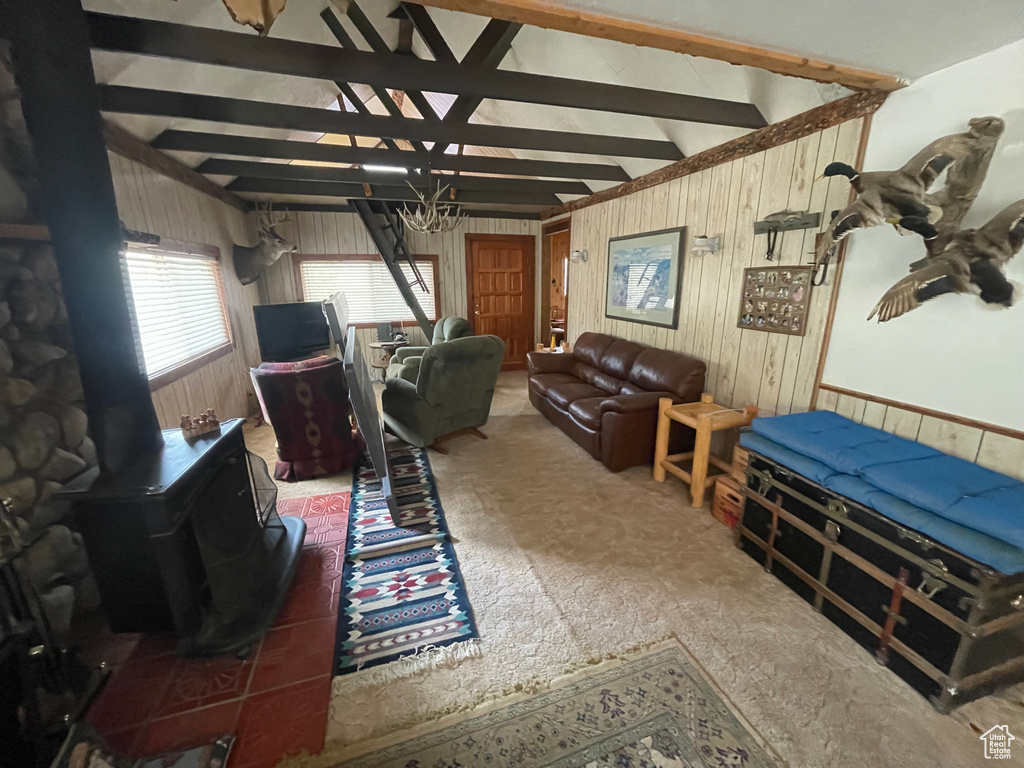Carpeted living area with a wood stove and wood walls
