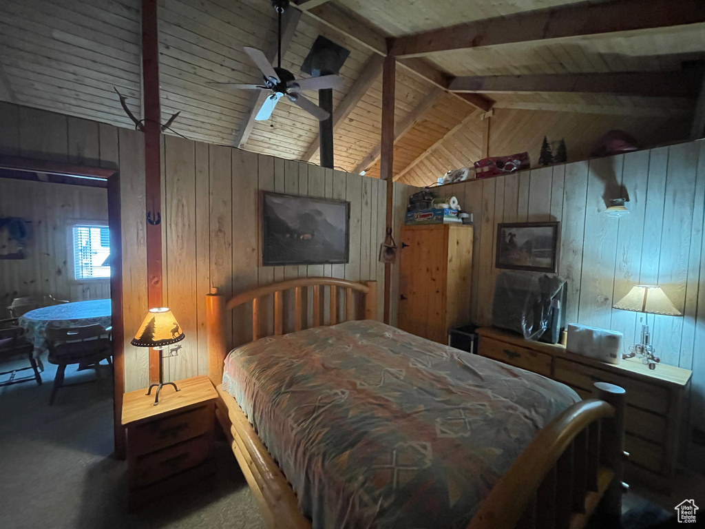 Carpeted bedroom featuring wood walls