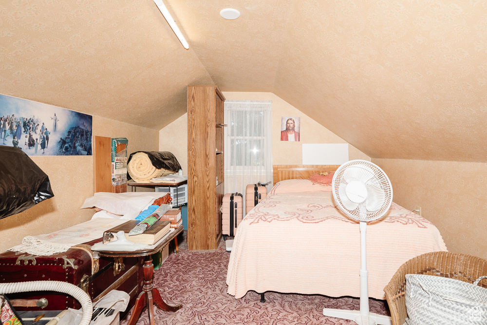 Bedroom with vaulted ceiling and a textured ceiling