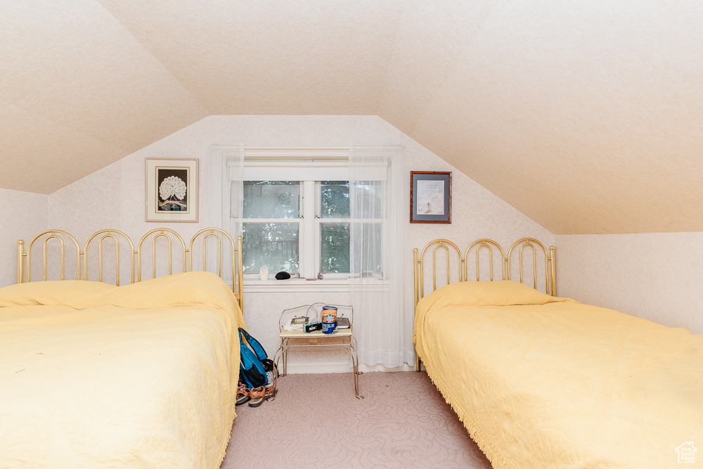 Bedroom featuring carpet flooring and vaulted ceiling