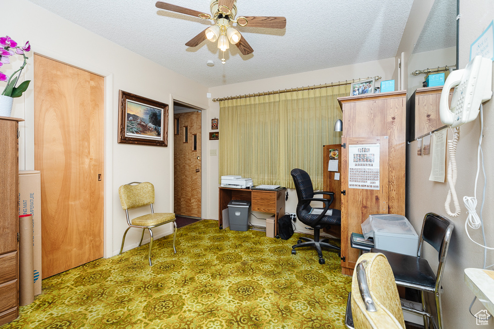 Office area featuring ceiling fan and a textured ceiling