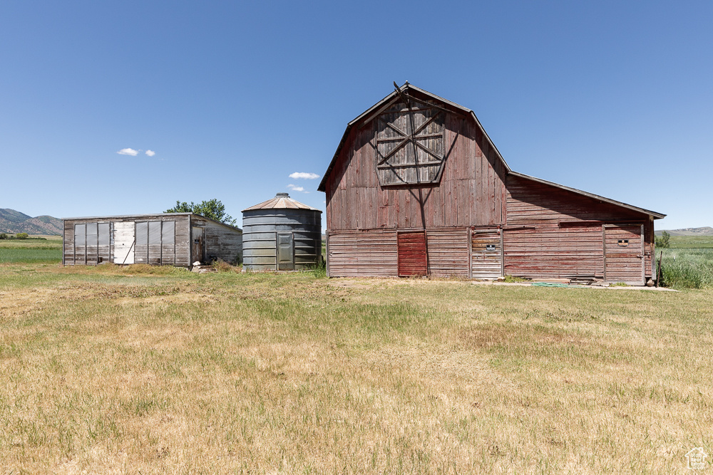 View of barn featuring a lawn