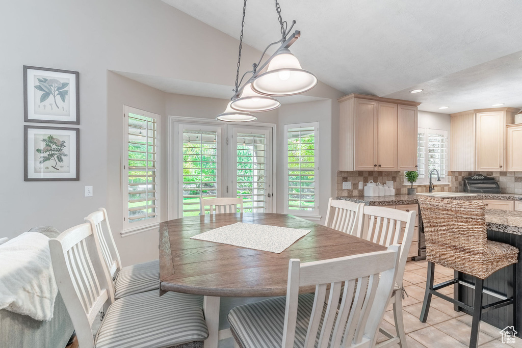 Dining area with lofted ceiling, recessed lighting, and light tile patterned floors