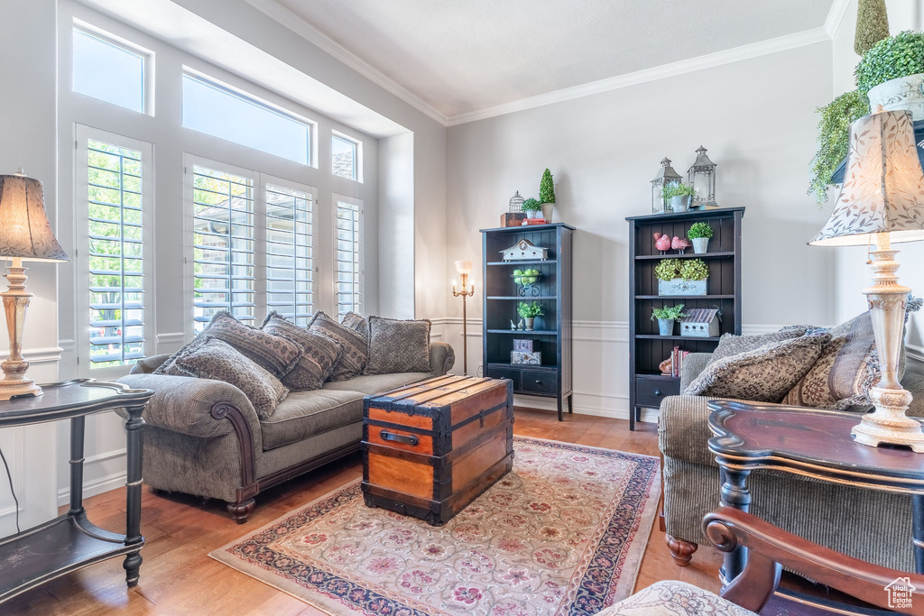 Living room with ornamental molding and wood finished floors