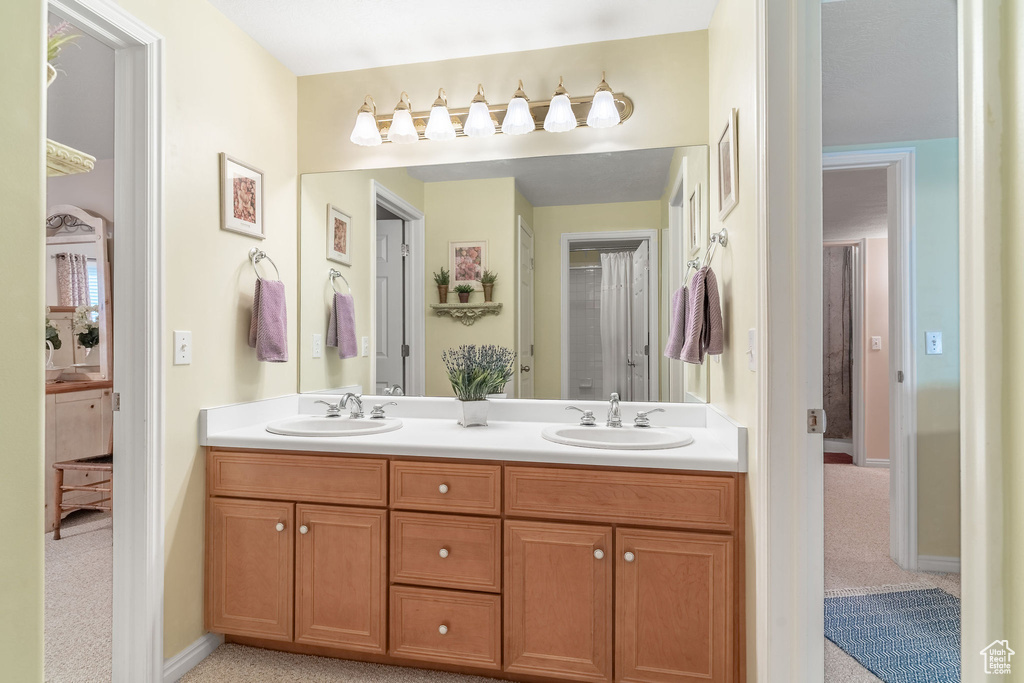 Full bathroom featuring double vanity and baseboards