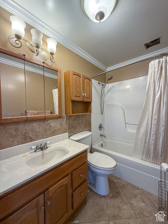 Full bathroom with ornamental molding, vanity, shower / tub combo with curtain, toilet, and tile patterned flooring