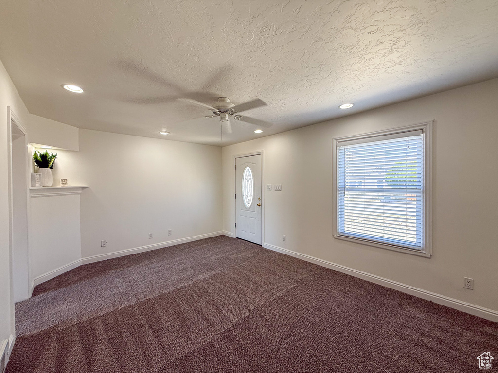 Entrance foyer with ceiling fan, recessed lighting, a textured ceiling, dark colored carpet, and baseboards