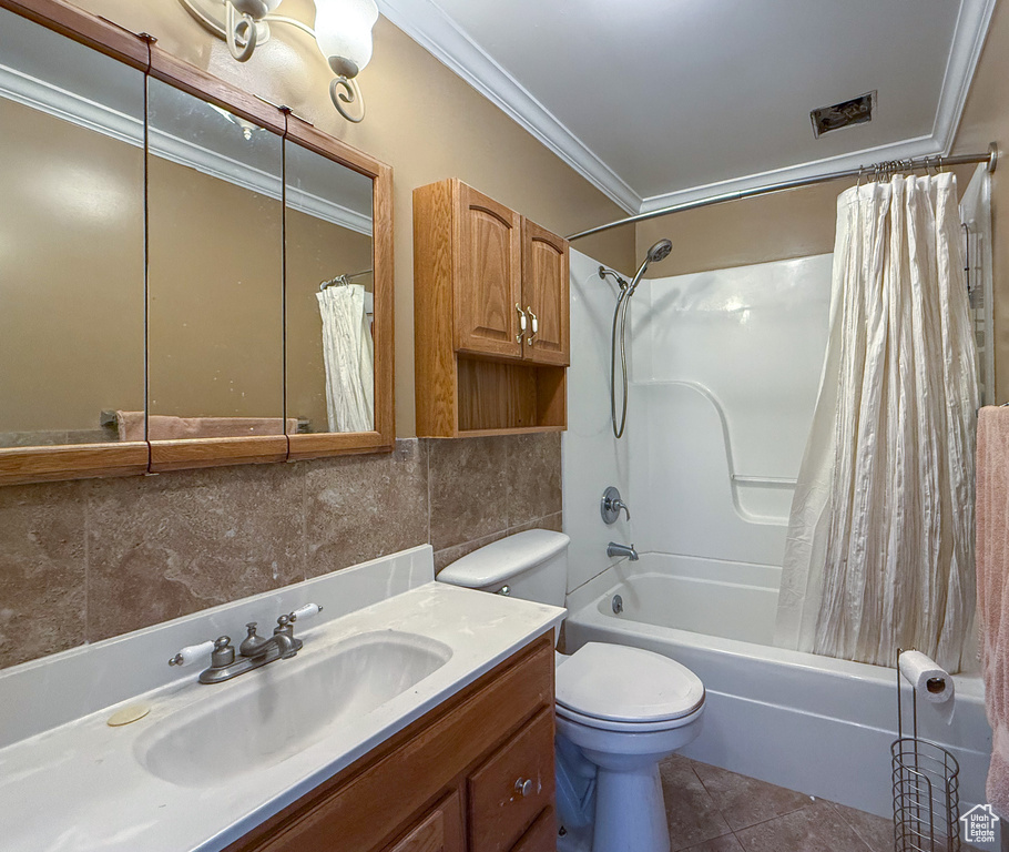 Full bath with ornamental molding, vanity, shower / tub combo with curtain, toilet, and decorative backsplash