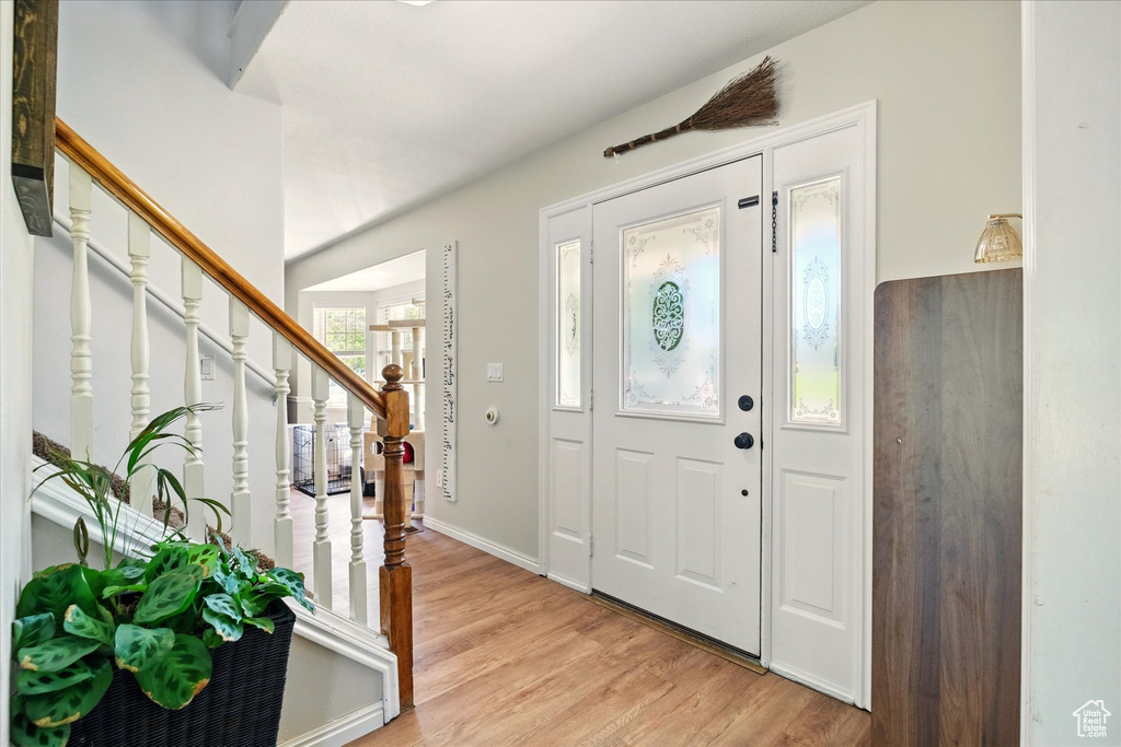 Entryway with light wood-style flooring, stairway, and baseboards