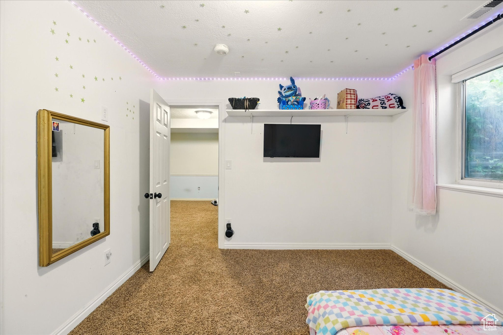 Unfurnished bedroom featuring carpet and baseboards