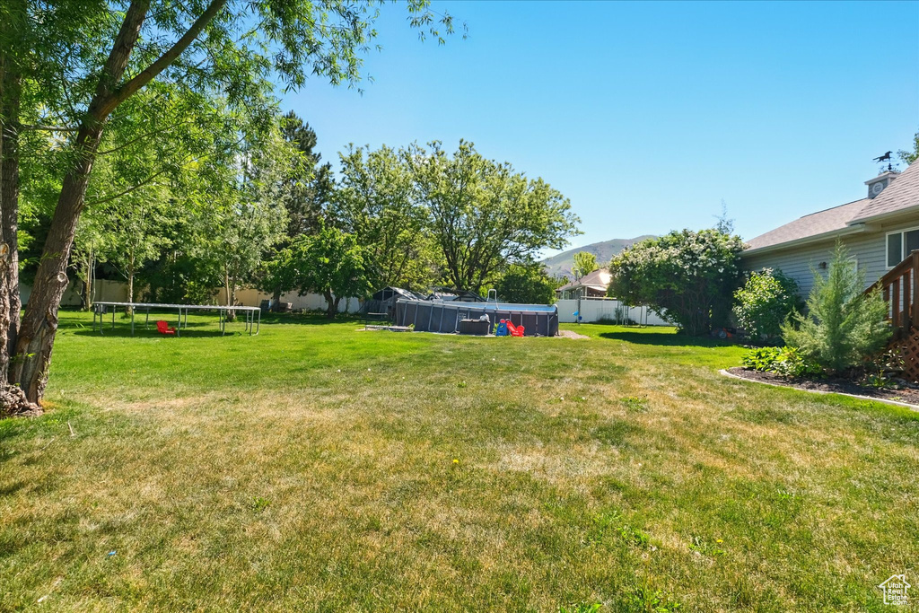 View of yard featuring a trampoline and a mountain view
