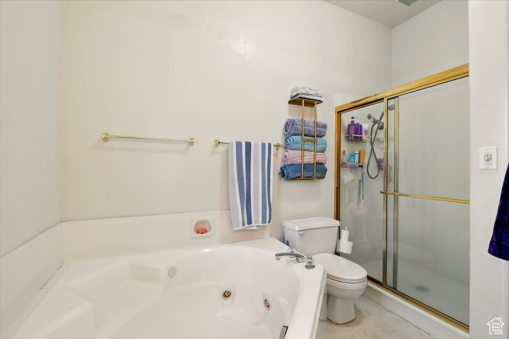 Full bath featuring toilet, a shower stall, and a whirlpool tub