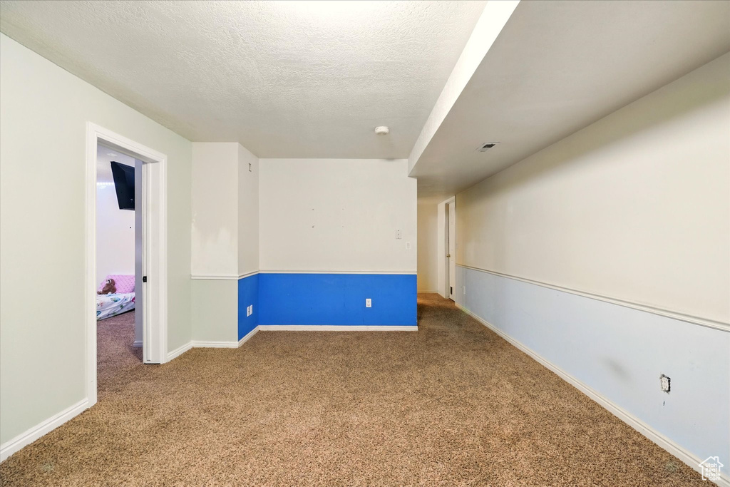 Carpeted empty room with baseboards and a textured ceiling