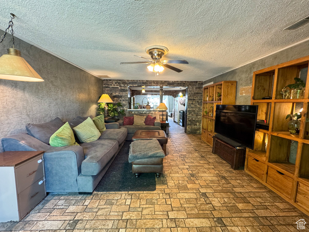 Living area with a ceiling fan and a textured ceiling