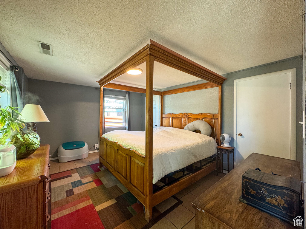 Tiled bedroom featuring a textured ceiling